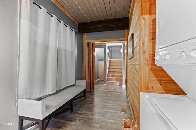 hallway featuring hardwood / wood-style flooring, stacked washer and clothes dryer, beam ceiling, and wooden ceiling