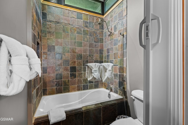 bathroom featuring toilet and tiled shower / bath combo