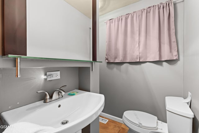 bathroom featuring sink, tile patterned floors, and toilet