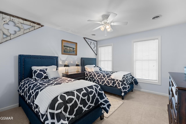 bedroom featuring multiple windows, ceiling fan, and light colored carpet