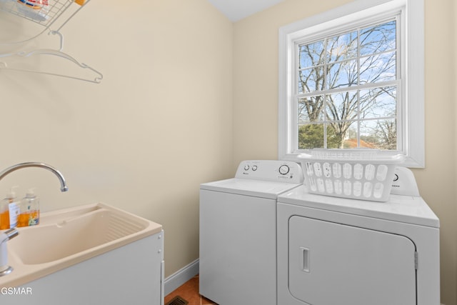 clothes washing area with sink and washing machine and clothes dryer