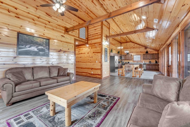 living room featuring a ceiling fan, wood ceiling, beamed ceiling, wood walls, and light wood-style flooring