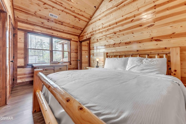bedroom with visible vents, wooden ceiling, wood finished floors, vaulted ceiling, and wood walls