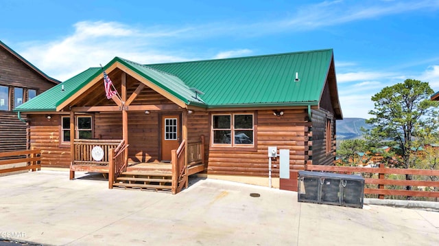 back of property featuring a patio area, metal roof, log exterior, and fence