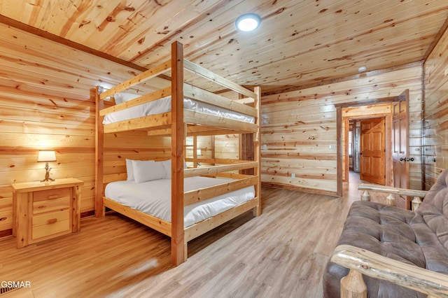 bedroom with wooden walls, light wood-style floors, and wood ceiling