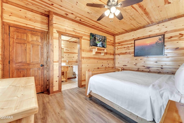 bedroom featuring wooden ceiling, ceiling fan, wooden walls, connected bathroom, and wood finished floors