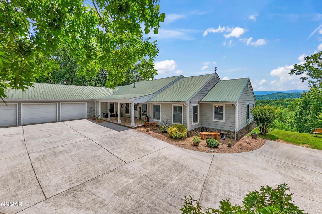 single story home with a mountain view, a porch, and a garage