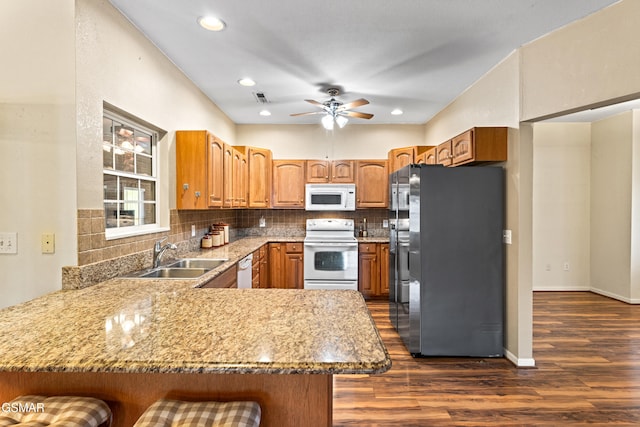 3351 Line Springs Rd, Sevierville, TN 37862 - kitchen with white appliances, a sink, a peninsula, dark wood-type flooring, and decorative backsplash