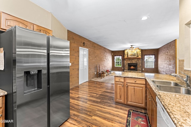 3351 Line Springs Rd, Sevierville, TN 37862 - kitchen featuring stainless steel fridge, a stone fireplace, a sink, dark wood-type flooring, and brick wall