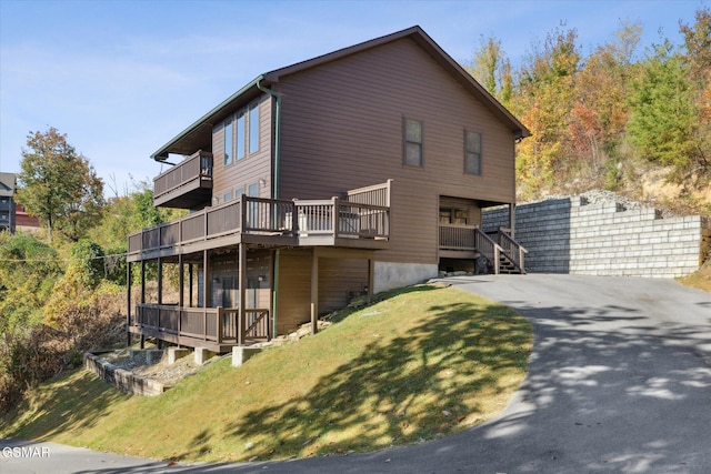 rear view of property with a deck and a lawn