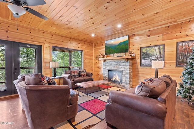 3181 Thomas Headrick Rd, Sevierville, TN 37862 - living room featuring a stone fireplace, wooden walls, ceiling fan, wood finished floors, and recessed lighting