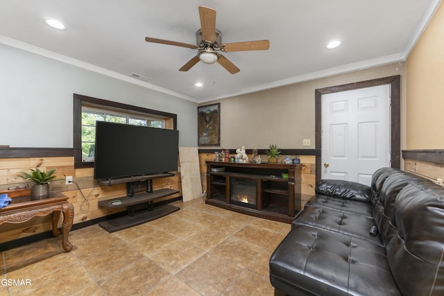 living area with ornamental molding, recessed lighting, and a wainscoted wall