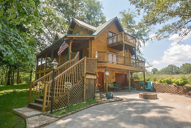 back of house with a patio, a balcony, and an outdoor fire pit