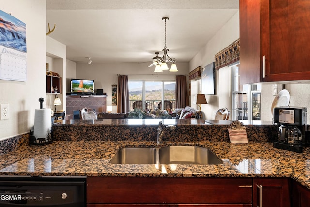 kitchen featuring open floor plan, dishwasher, dark stone counters, and a sink