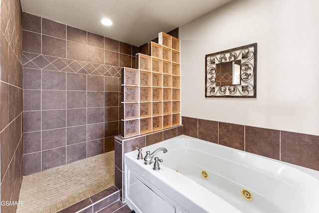 bathroom with recessed lighting, a whirlpool tub, and walk in shower