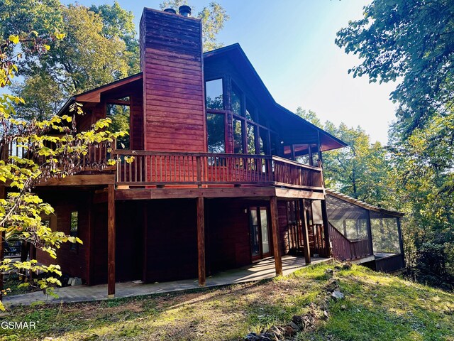 rear view of property with a patio area and a wooden deck