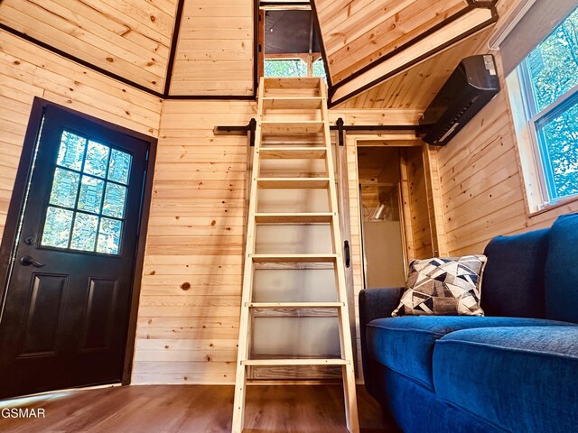 interior space featuring hardwood / wood-style flooring, wood walls, and high vaulted ceiling