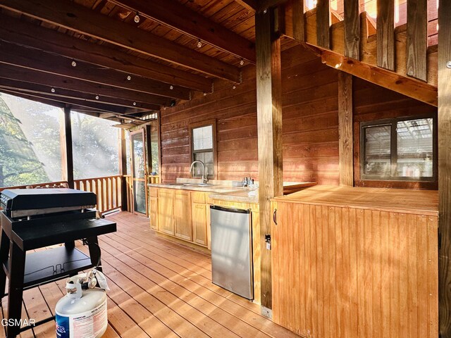 bar with beamed ceiling, wood counters, wood walls, and fridge