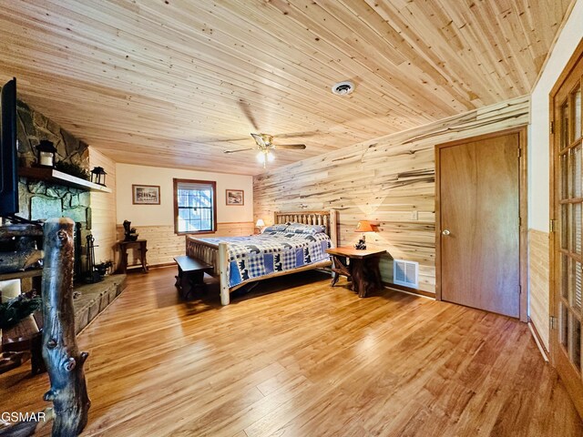 bedroom featuring hardwood / wood-style flooring, ceiling fan, wood walls, and wood ceiling