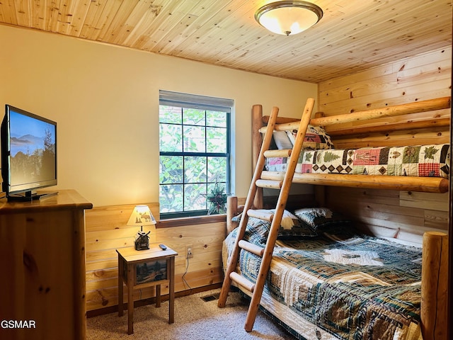 bedroom featuring wooden walls, carpet floors, and wooden ceiling