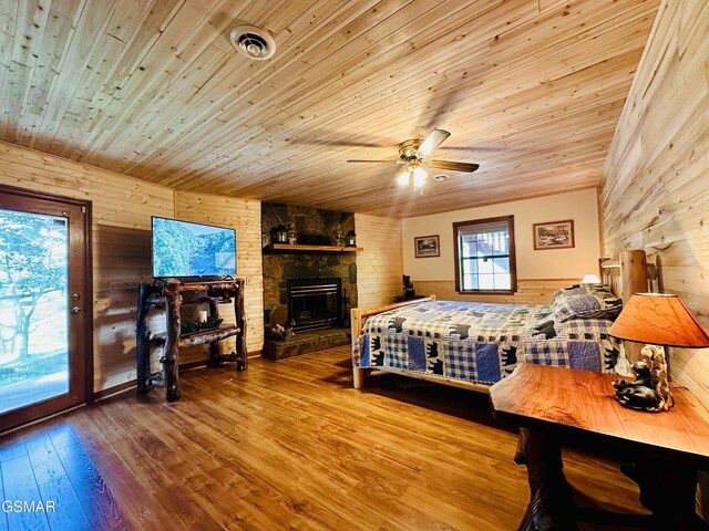 bedroom with access to outside, ceiling fan, wooden ceiling, and wood walls