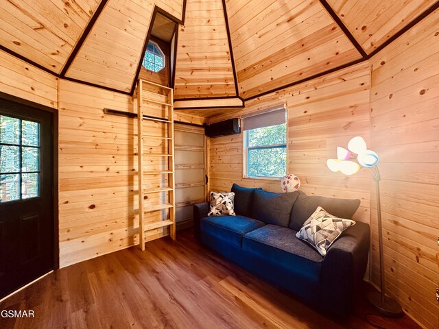 unfurnished room with wood walls, hardwood / wood-style floors, high vaulted ceiling, and wood ceiling