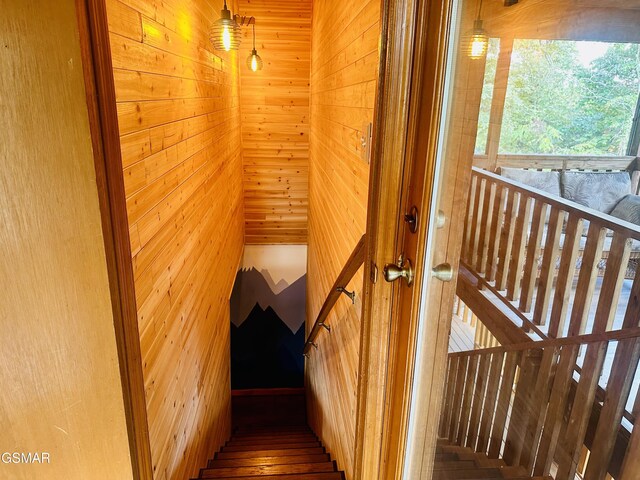 stairway featuring wood walls