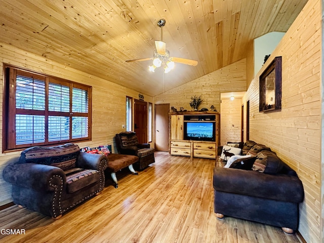 living room featuring ceiling fan, light hardwood / wood-style flooring, wooden ceiling, and wooden walls