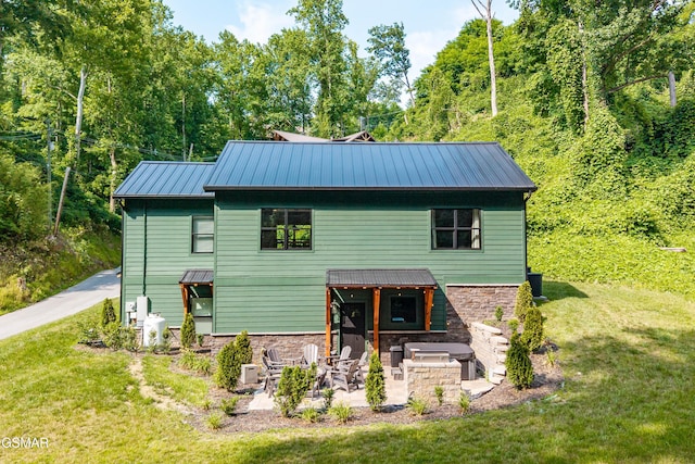 706 Kelly St, Gatlinburg, TN 37738 - view of front of house with a front yard, a patio area, a metal roof, and stone siding
