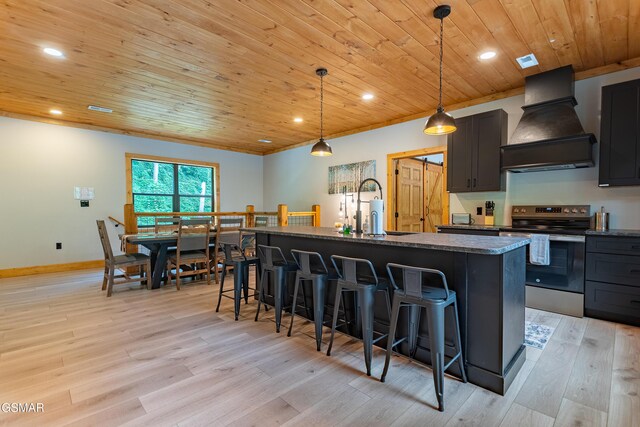 706 Kelly St, Gatlinburg, TN 37738 - kitchen with stainless steel electric range oven, premium range hood, wooden ceiling, a breakfast bar area, and light wood finished floors