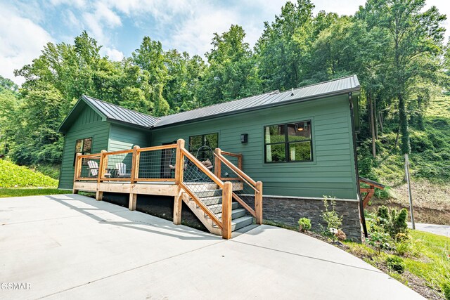 706 Kelly St, Gatlinburg, TN 37738 - view of front facade featuring a metal roof, a deck, a standing seam roof, and a patio