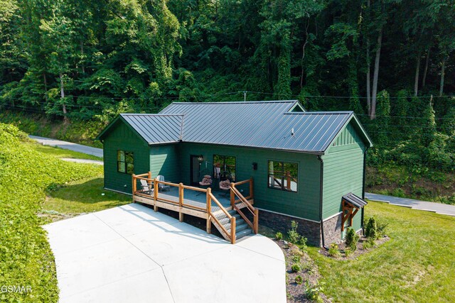 706 Kelly St, Gatlinburg, TN 37738 - view of front of house with a front lawn, a metal roof, a wooden deck, and a view of trees