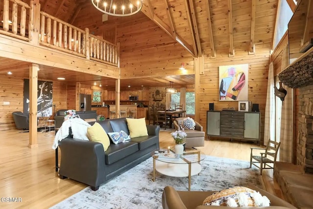 living room featuring beam ceiling, high vaulted ceiling, wood walls, light hardwood / wood-style floors, and wood ceiling