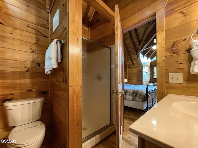 bathroom with wooden walls, vanity, an enclosed shower, and toilet