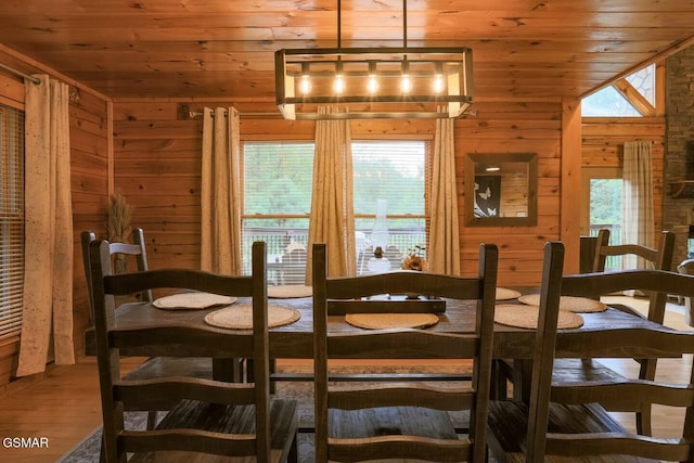 dining area with hardwood / wood-style floors, wood walls, and wood ceiling