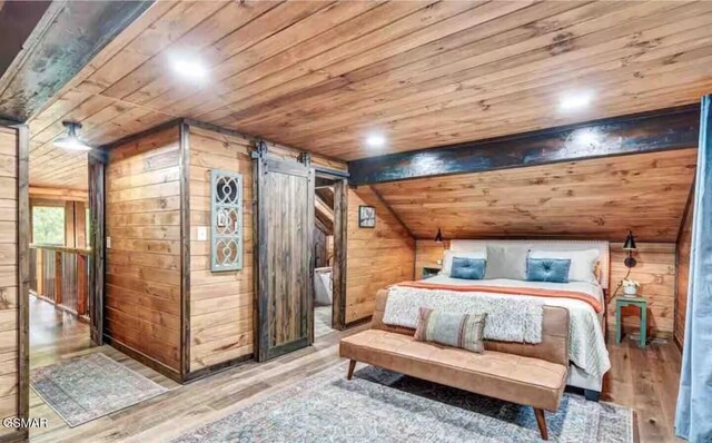 2379 Headrick Lead, Sevierville, TN 37862 - bedroom featuring wood ceiling, wooden walls, a barn door, wood finished floors, and vaulted ceiling