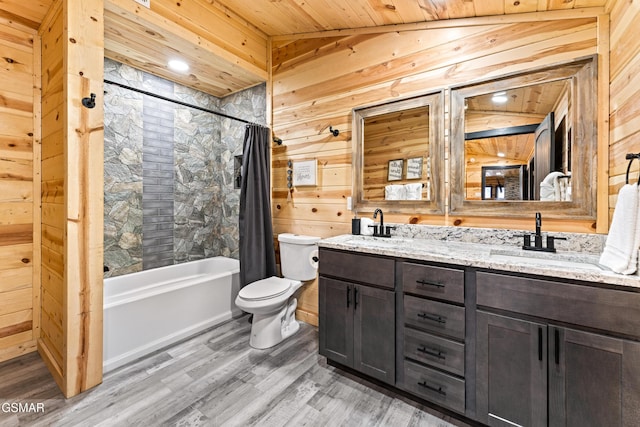 bathroom with toilet, wood walls, and a sink