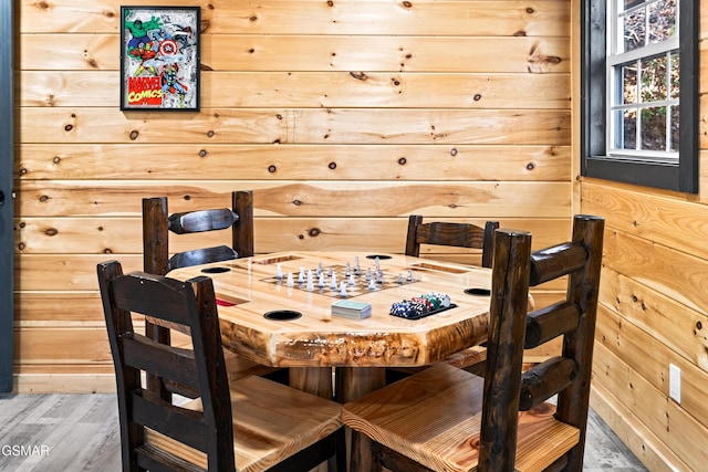 dining area with wood walls and wood finished floors