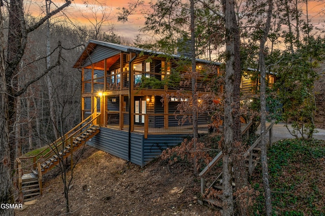 exterior space featuring stairway, log veneer siding, a balcony, and a porch
