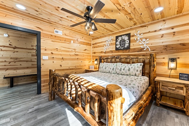 bedroom with wood ceiling, wood walls, wood finished floors, and visible vents