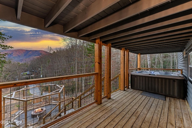 wooden deck with a hot tub and a mountain view