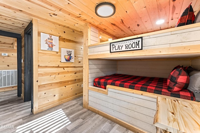 bedroom with wooden walls, wooden ceiling, and a sauna