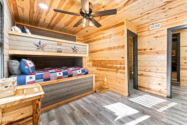 bedroom with wooden walls, wood ceiling, and visible vents