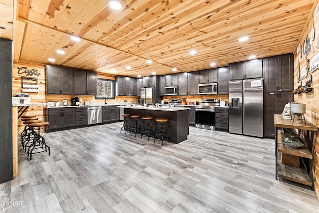 kitchen featuring dark brown cabinetry, appliances with stainless steel finishes, light countertops, light wood-style flooring, and wood ceiling