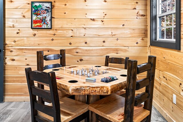 dining area with wood walls and wood finished floors