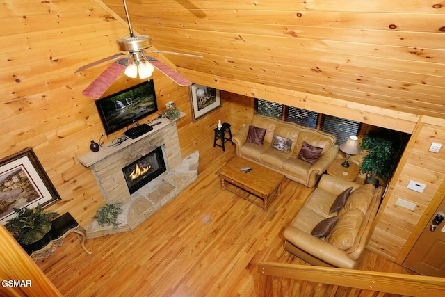448 Silver Maple Ln, Gatlinburg, TN 37738 - living room with a stone fireplace, wood finished floors, wooden walls, ceiling fan, and lofted ceiling