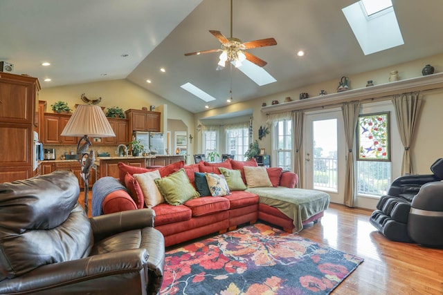 living room with light wood-type flooring, ceiling fan, and a healthy amount of sunlight