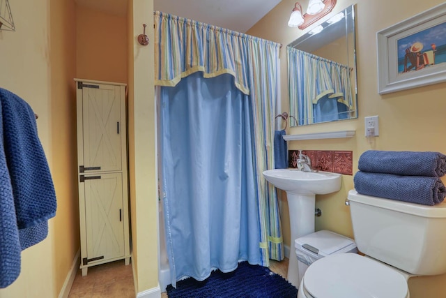 bathroom with tile patterned floors, a shower with curtain, and toilet