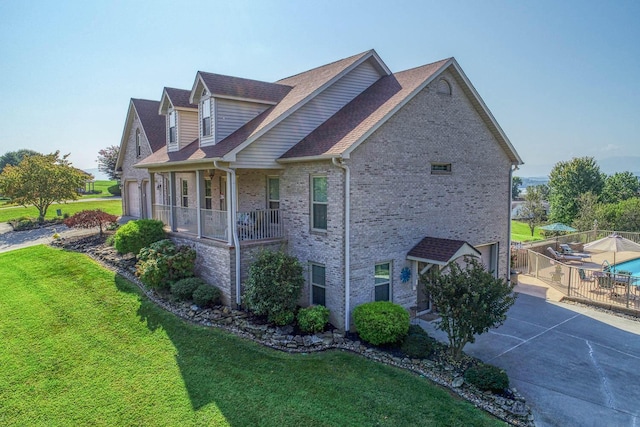 view of side of home featuring a yard and a porch