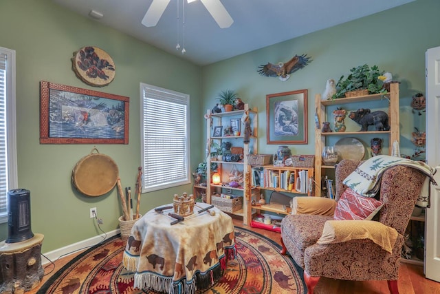 living area with hardwood / wood-style floors and ceiling fan